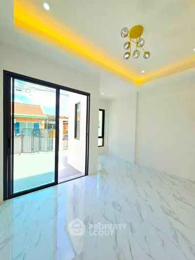 Spacious modern living room with marble flooring and large sliding glass doors opening to a balcony.