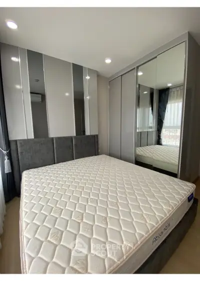 Modern bedroom with mirrored wardrobe and comfortable mattress