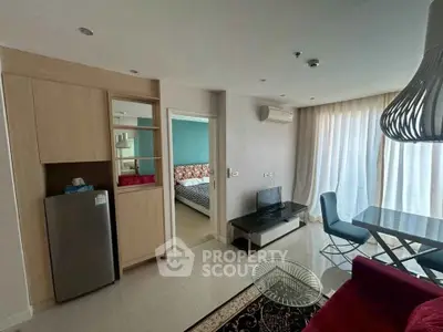 Modern apartment living room with dining area and view into bedroom, featuring stylish decor and natural light.