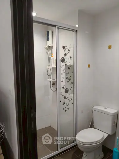 Modern bathroom with sleek shower enclosure and toilet in a contemporary home.