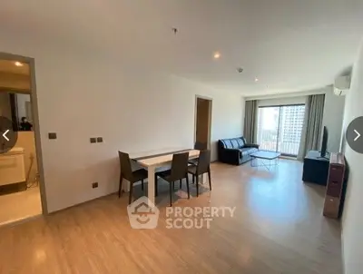 Spacious living room with ample natural light, hardwood flooring, and a cozy dining area, perfect for entertaining guests or relaxing.