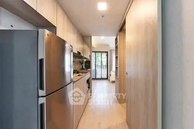Modern kitchen with sleek appliances and open layout leading to a balcony view.