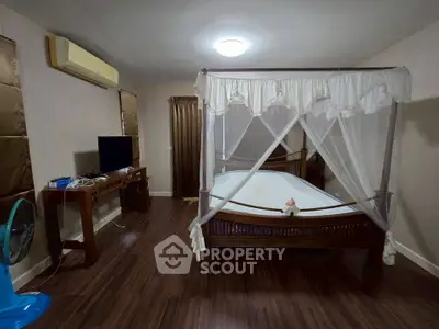 Spacious bedroom with elegant canopy bed and modern amenities for ultimate comfort.