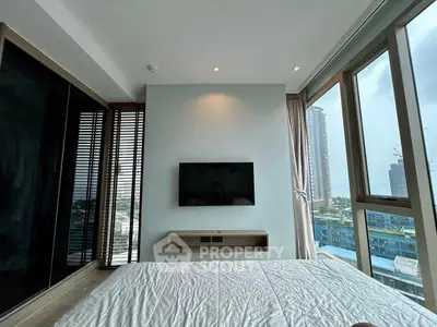 Modern bedroom with city view and wall-mounted TV