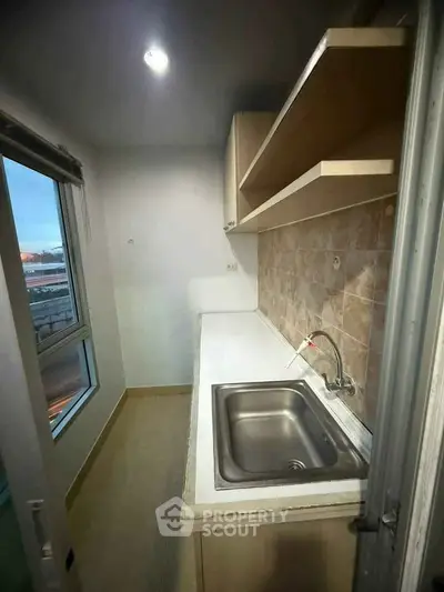 Compact kitchen with sleek countertop and modern sink, ideal for urban living.