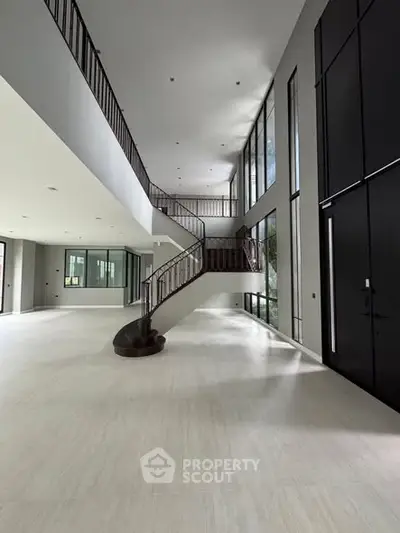 Luxurious modern interior with grand staircase and high ceilings.