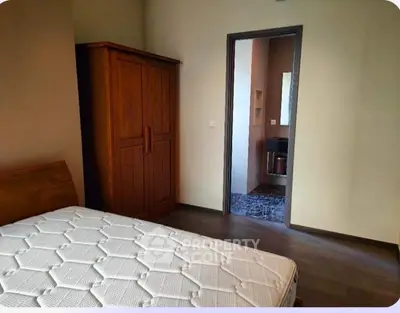 Cozy bedroom with wooden wardrobe and comfortable mattress, ideal for restful nights.