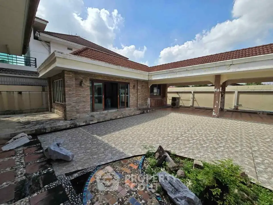 Spacious courtyard with modern paving and lush greenery in a luxurious home