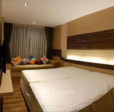Modern bedroom with twin beds and cozy seating area, perfect for relaxation.