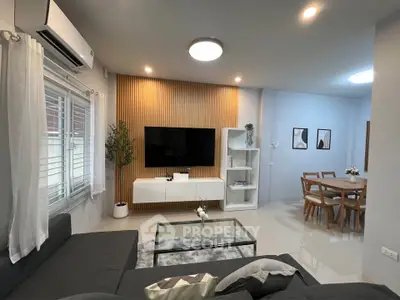 Modern living room with sleek furniture and dining area, featuring stylish decor and ample natural light.