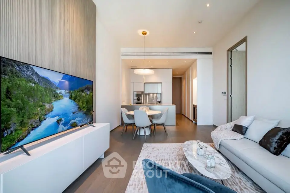 Luxurious modern living room with open kitchen, elegant decor, and large TV, perfect for stylish urban living.