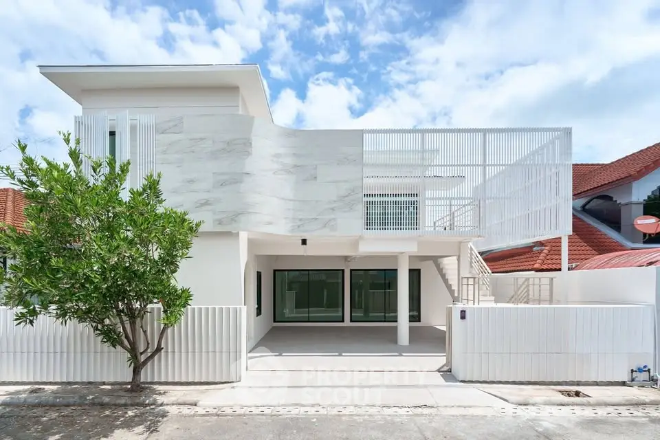 Modern white two-story house with unique facade and spacious driveway