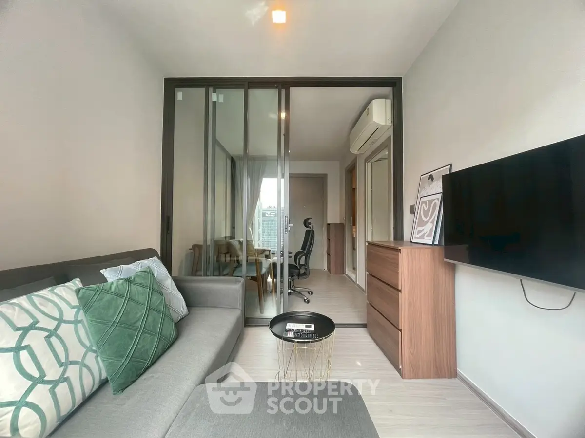Modern living room with sleek furniture and wall-mounted TV, featuring a cozy ambiance.