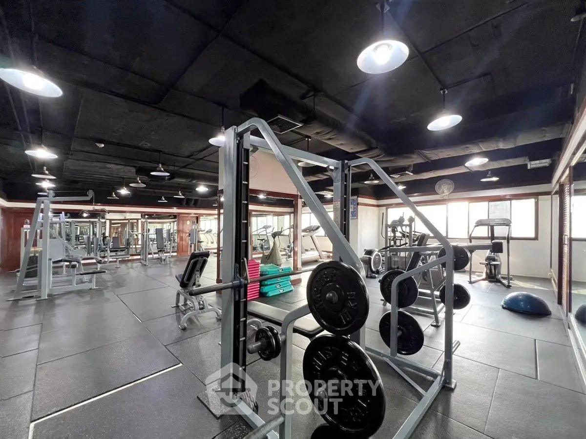 Spacious modern gym with state-of-the-art equipment and ample natural light.