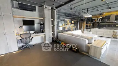 Modern industrial-style living room with open kitchen and home office setup