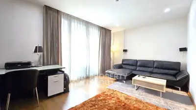 Spacious modern living room with sleek black sofa and natural light