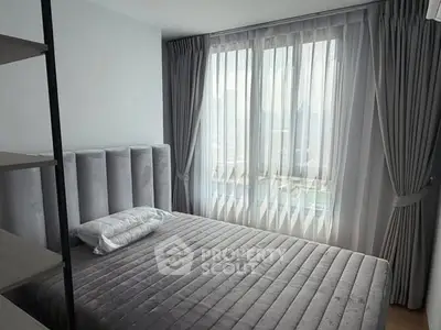 Modern bedroom with elegant gray decor and large window for natural light