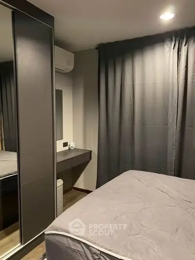 Cozy modern bedroom with mirrored wardrobe and elegant gray curtains.