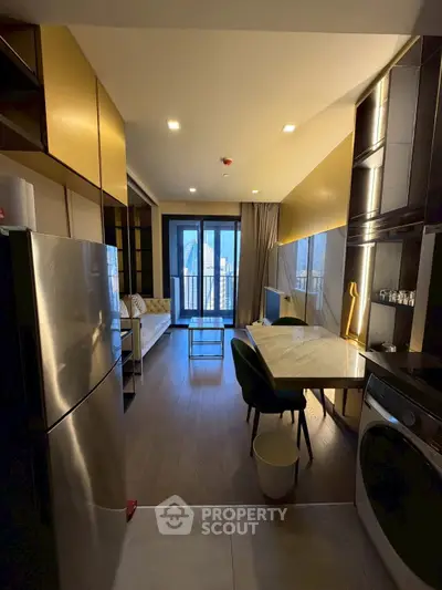 Modern apartment with open kitchen and living area, featuring sleek appliances and stylish decor.
