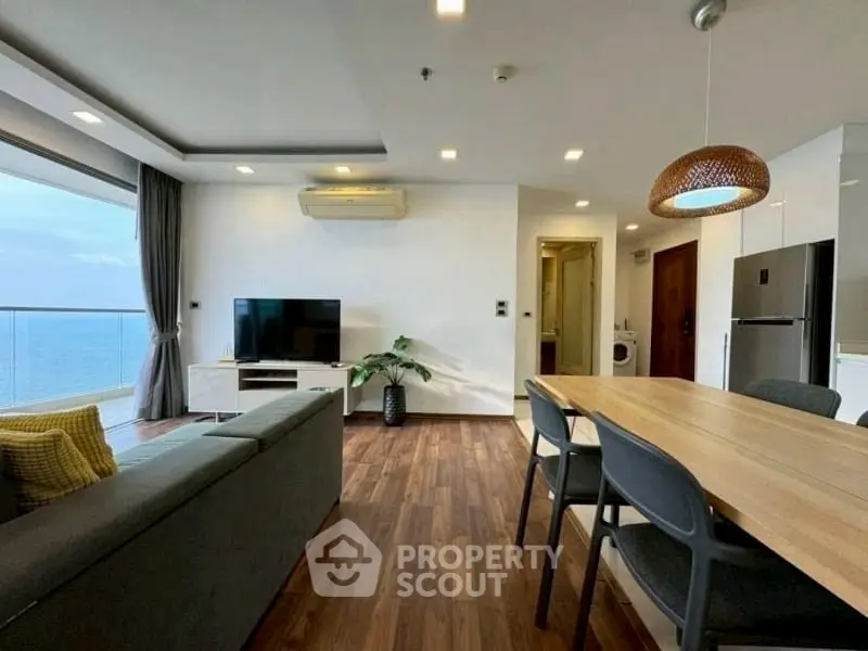 Modern living room with ocean view, open kitchen, and stylish dining area.