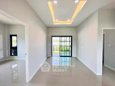 Spacious modern living room with sleek tile flooring and large windows for natural light.