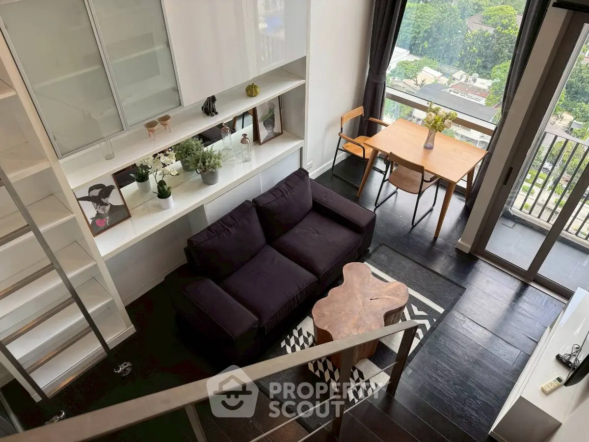 Stylish modern living room with balcony view, featuring sleek furniture and abundant natural light.