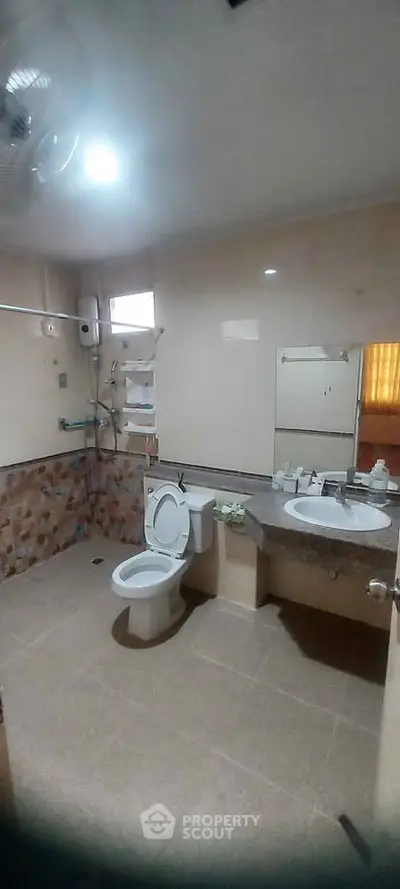 Spacious bathroom with modern fixtures and large mirror