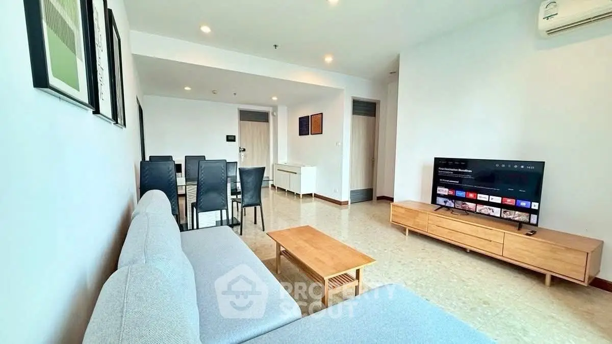 Spacious modern living room with sleek furniture and wall-mounted TV