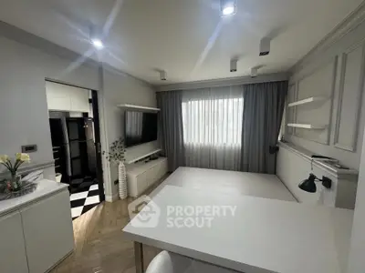 Modern living room with sleek design and open kitchen layout, featuring stylish lighting and elegant decor.