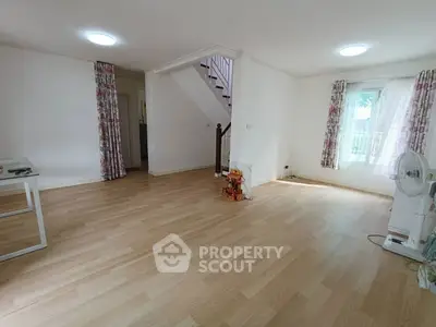 Spacious living room with wooden flooring and natural light