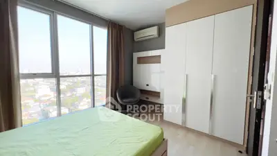 Modern bedroom with large windows offering stunning city views, featuring sleek furniture and ample natural light.