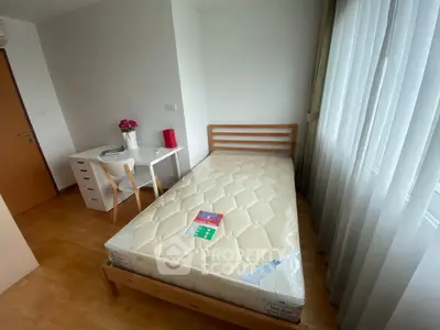 Cozy bedroom with single bed, desk, and large window offering natural light.