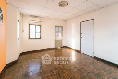 Spacious empty room with parquet flooring and natural light