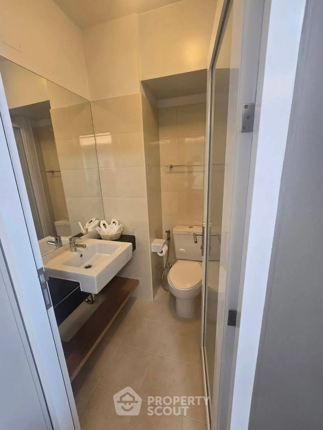 Modern bathroom with sleek fixtures and large mirror in a contemporary apartment.