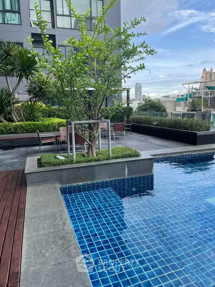 Luxurious rooftop pool with city views and lush greenery, perfect for relaxation and leisure.