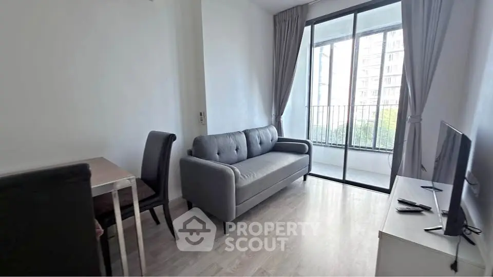 Modern living room with sleek sofa and balcony view in a stylish apartment.
