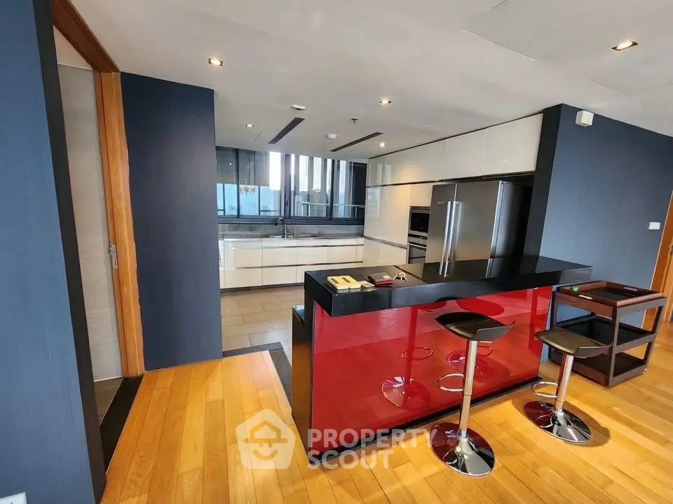 Modern kitchen with sleek red island and stainless steel appliances