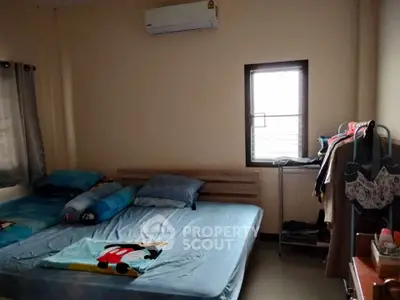 Cozy bedroom with air conditioning and natural light, featuring a comfortable bed and organized storage space.