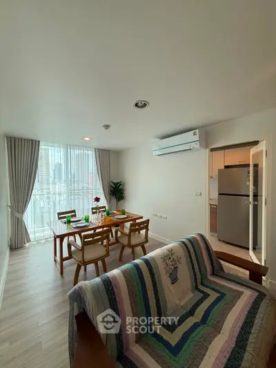 Spacious living room with dining area and balcony view in modern apartment.