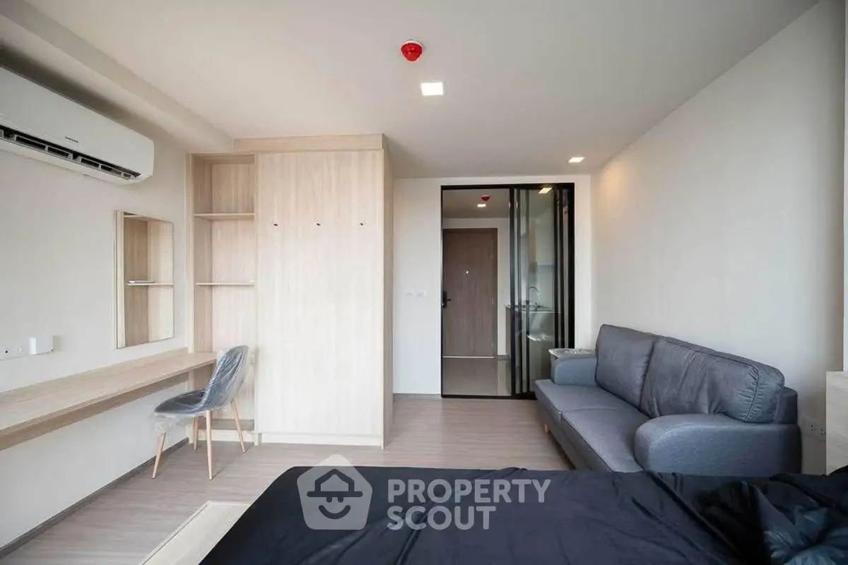 Modern studio apartment with sleek furnishings and ample natural light.