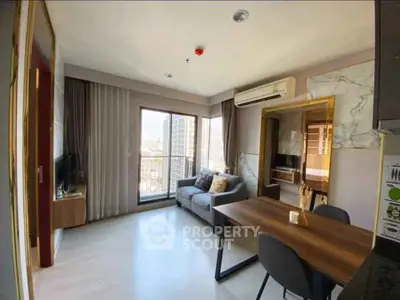 Modern living room with balcony view, stylish furniture, and air conditioning in a high-rise apartment.