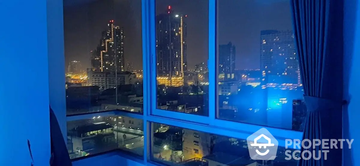 Stunning city night view from high-rise apartment window with modern skyline.