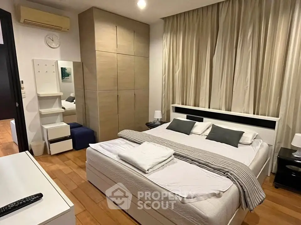 Spacious bedroom with modern decor and ample storage in a stylish apartment.