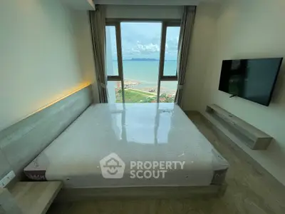 Luxurious bedroom with stunning ocean view and modern amenities in high-rise apartment.