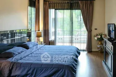Luxurious bedroom with elegant decor and large windows offering natural light.