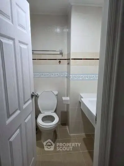 Compact bathroom with modern fixtures and tiled walls