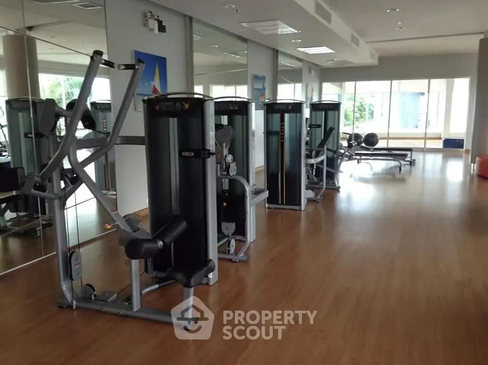 Spacious modern gym with state-of-the-art fitness equipment and mirrored walls.