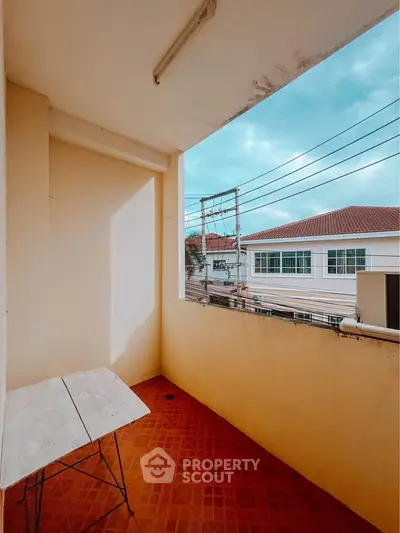 Charming balcony with terracotta tiles and scenic neighborhood view, perfect for relaxation and outdoor dining.