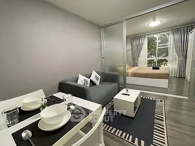 Modern open-plan living room with cozy dining area and bedroom view