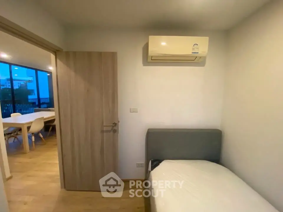 Cozy bedroom with air conditioning and view into modern dining area